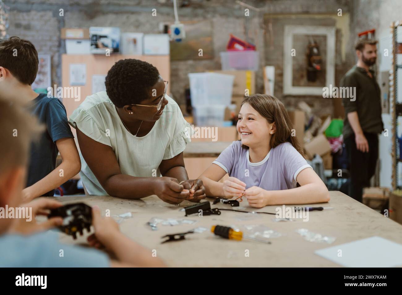 Heureux étudiant et enseignant interagissant les uns avec les autres à l'atelier de technologie à l'école Banque D'Images