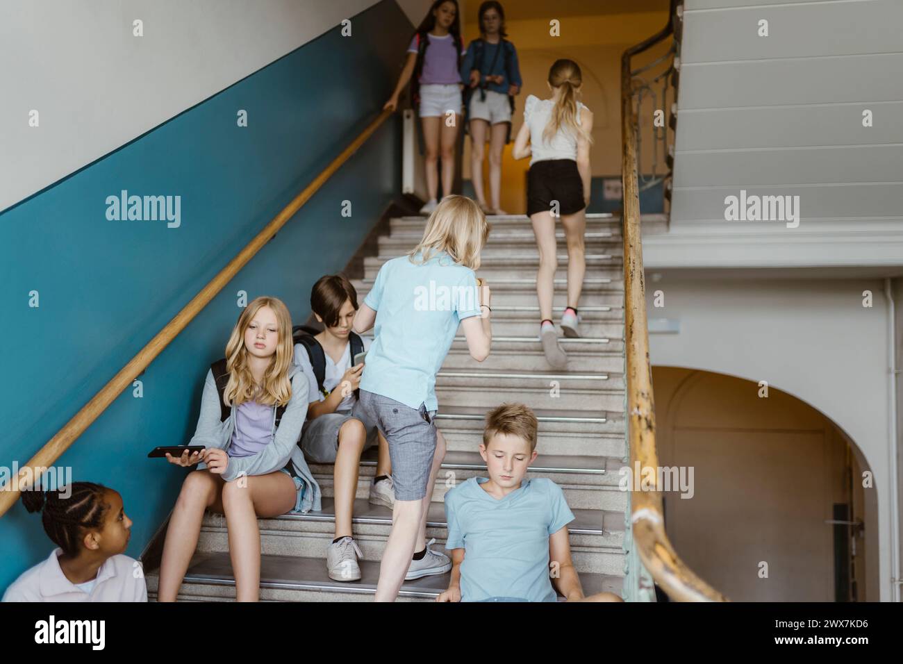 Étudiants hommes et femmes dans les escaliers pendant la récréation à l'école Banque D'Images