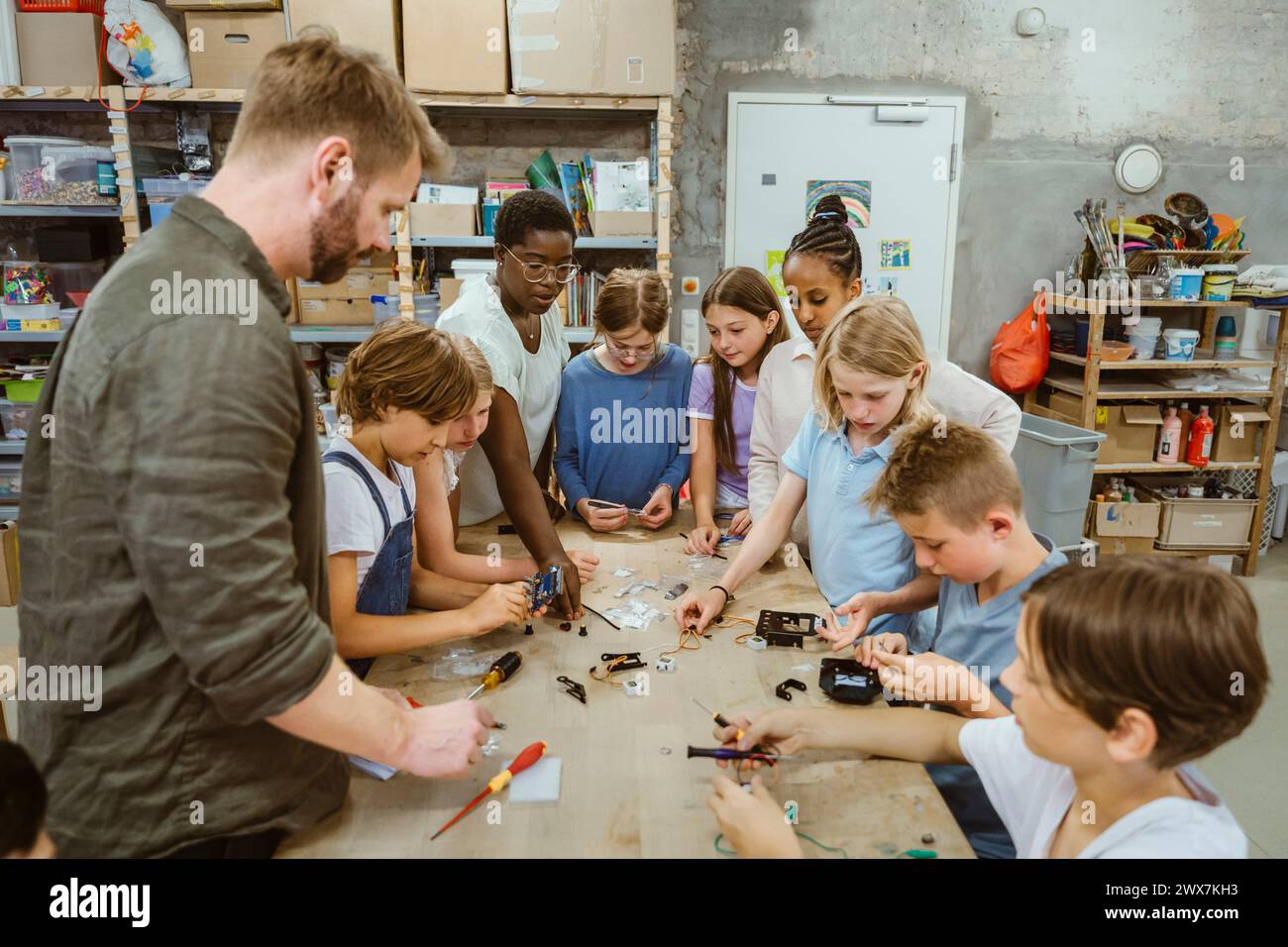 Groupe d'étudiants hommes et femmes travaillant sur le projet de robotique avec des enseignants dans l'atelier de technologie à l'école Banque D'Images