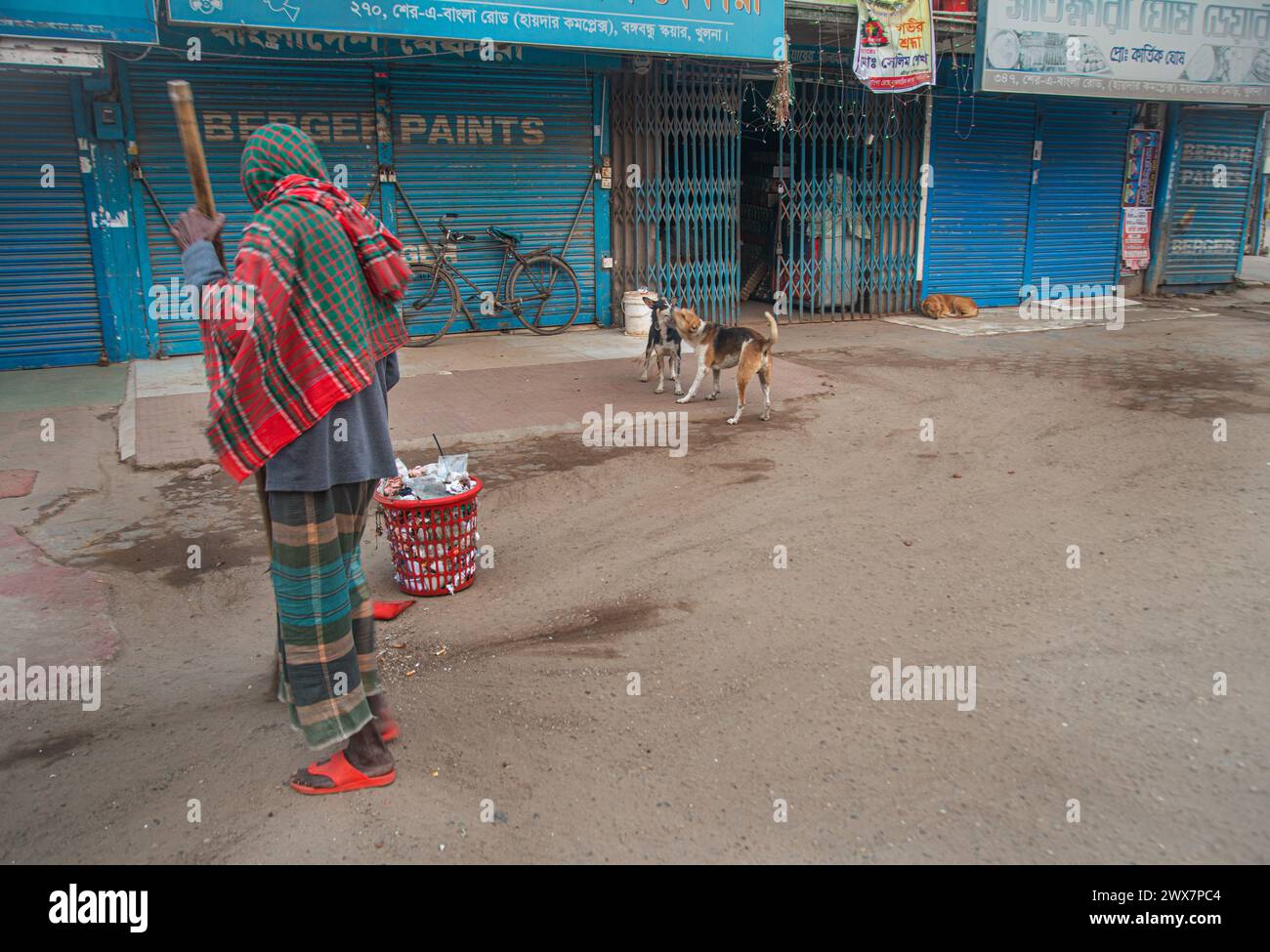 Un nettoyeur de la corporation municipale, est vu balayer les rues le matin à Khulna, au Bangladesh. Banque D'Images