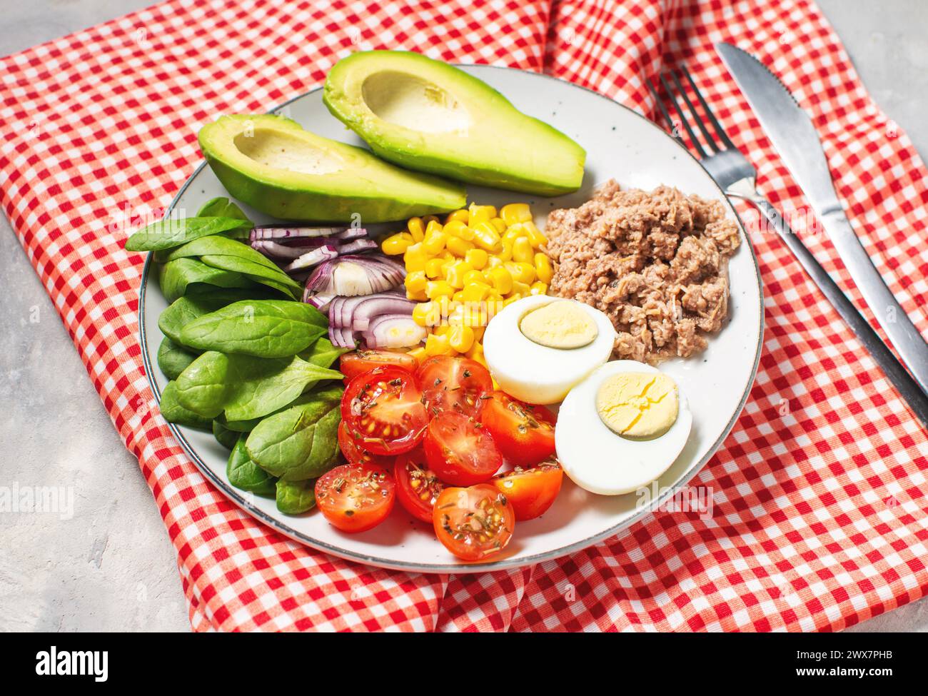 Bol à lunch sain : oeuf, thon, avocat, tomates cerises salade de maïs oignon Banque D'Images
