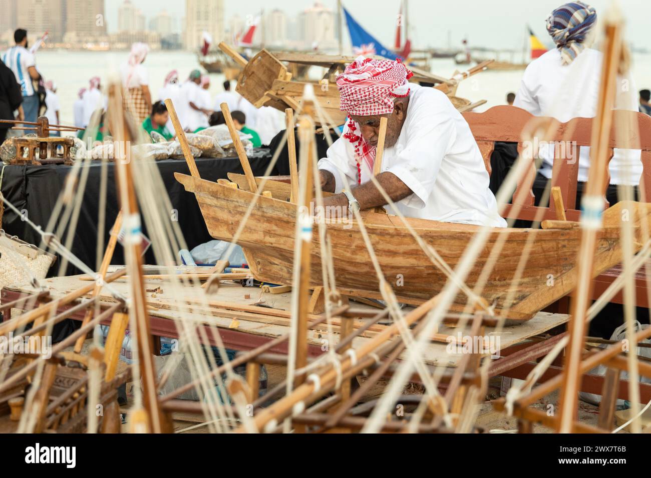Un artiste créatif construisant un petit modèle d'un bateau de pêche traditionnel arabe. Banque D'Images