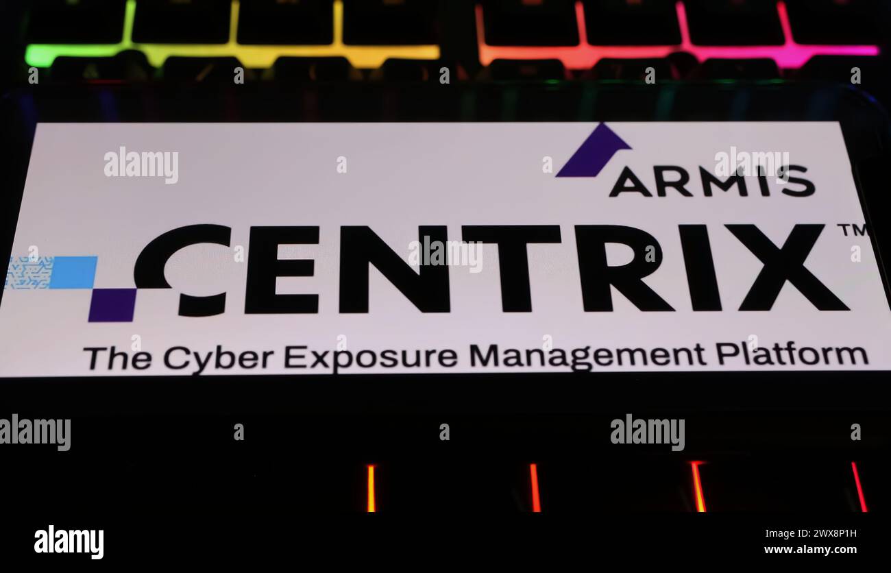 Viersen, Allemagne - 9 mars. 2024 : gros plan de smartphone sur clavier d'ordinateur avec lettrage de logo de la plate-forme de cyber-gestion Armis Centrix Banque D'Images