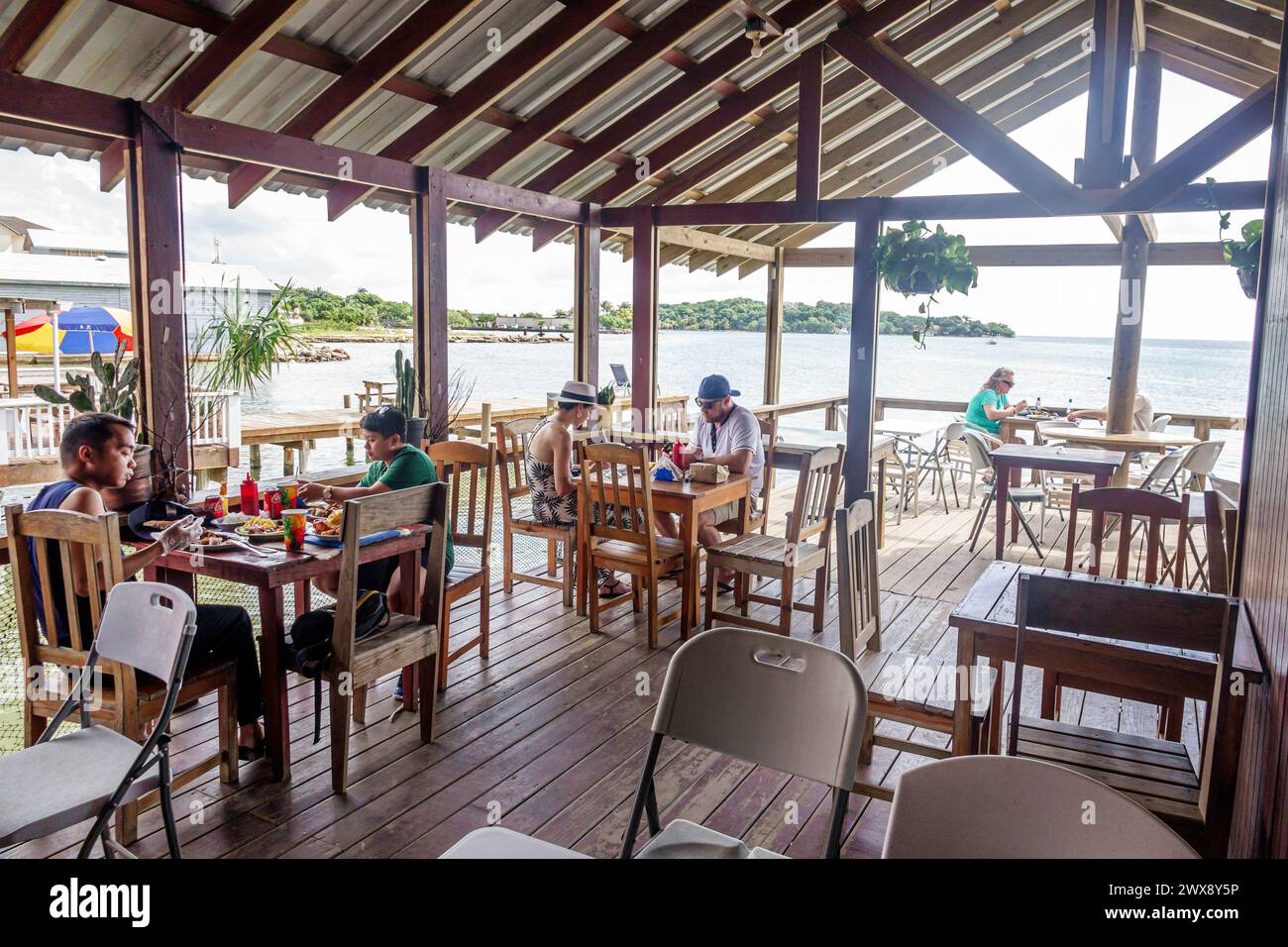 Port Roatan Honduras, Coxen Hole, Bay Islands, main Street, front de mer en plein air look Out Restaurant & Bar, tables chaises, homme homme masculin, femme femme femme femme fema Banque D'Images