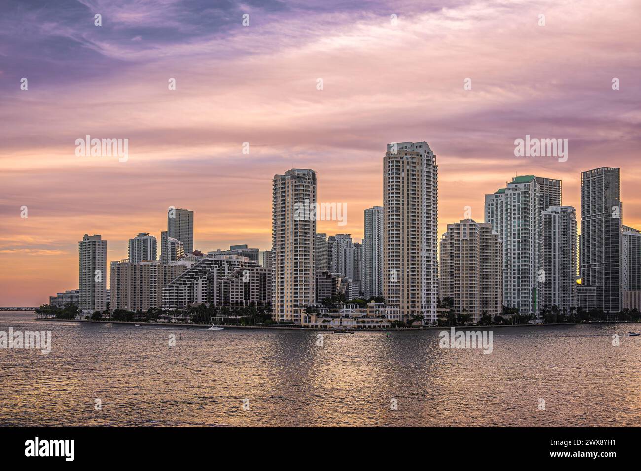 Miami, Floride, États-Unis - 29 juillet 2023 : ciel coloré chaud au-dessus des bâtiments sur l'île de Brickell Key au soir 19:43. La statue Centinel entre Tequesta poi Banque D'Images