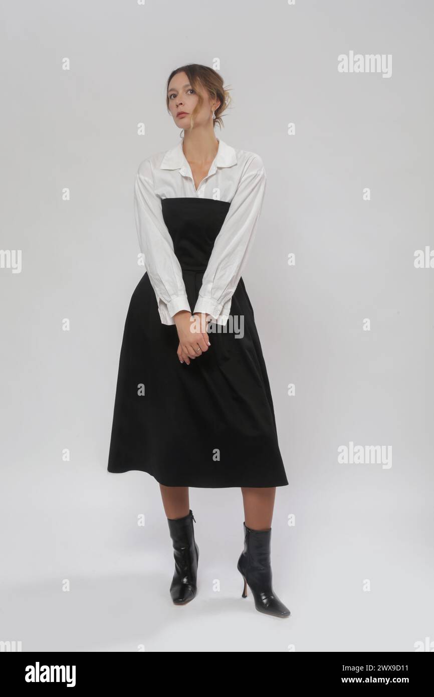 Série de photos de studio de modèle féminin portant chemise blanche boutonnée sous le tube noir top Une robe midi ligne Banque D'Images
