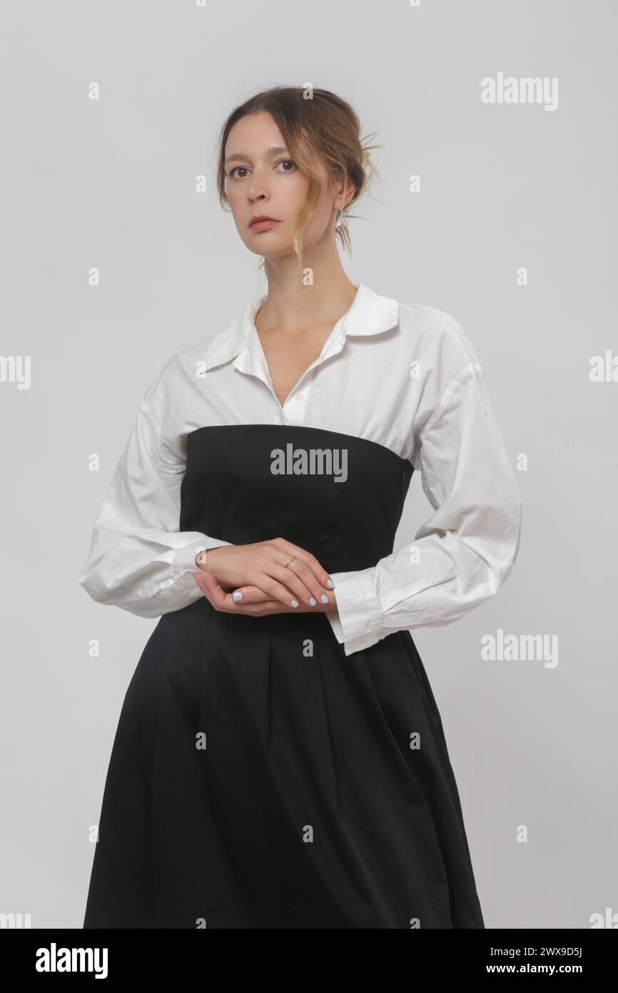 Série de photos de studio de modèle féminin portant chemise blanche boutonnée sous le tube noir top Une robe midi ligne Banque D'Images