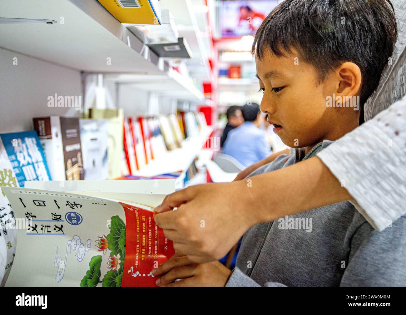 Bangkok, Thaïlande. 28 mars 2024. Un visiteur choisit des livres chinois à la Foire internationale du livre de Bangkok 2024 à Bangkok, Thaïlande, le 28 mars 2024. La foire du livre a débuté ici jeudi et durera jusqu'au 8 avril. Crédit : Wang Teng/Xinhua/Alamy Live News Banque D'Images
