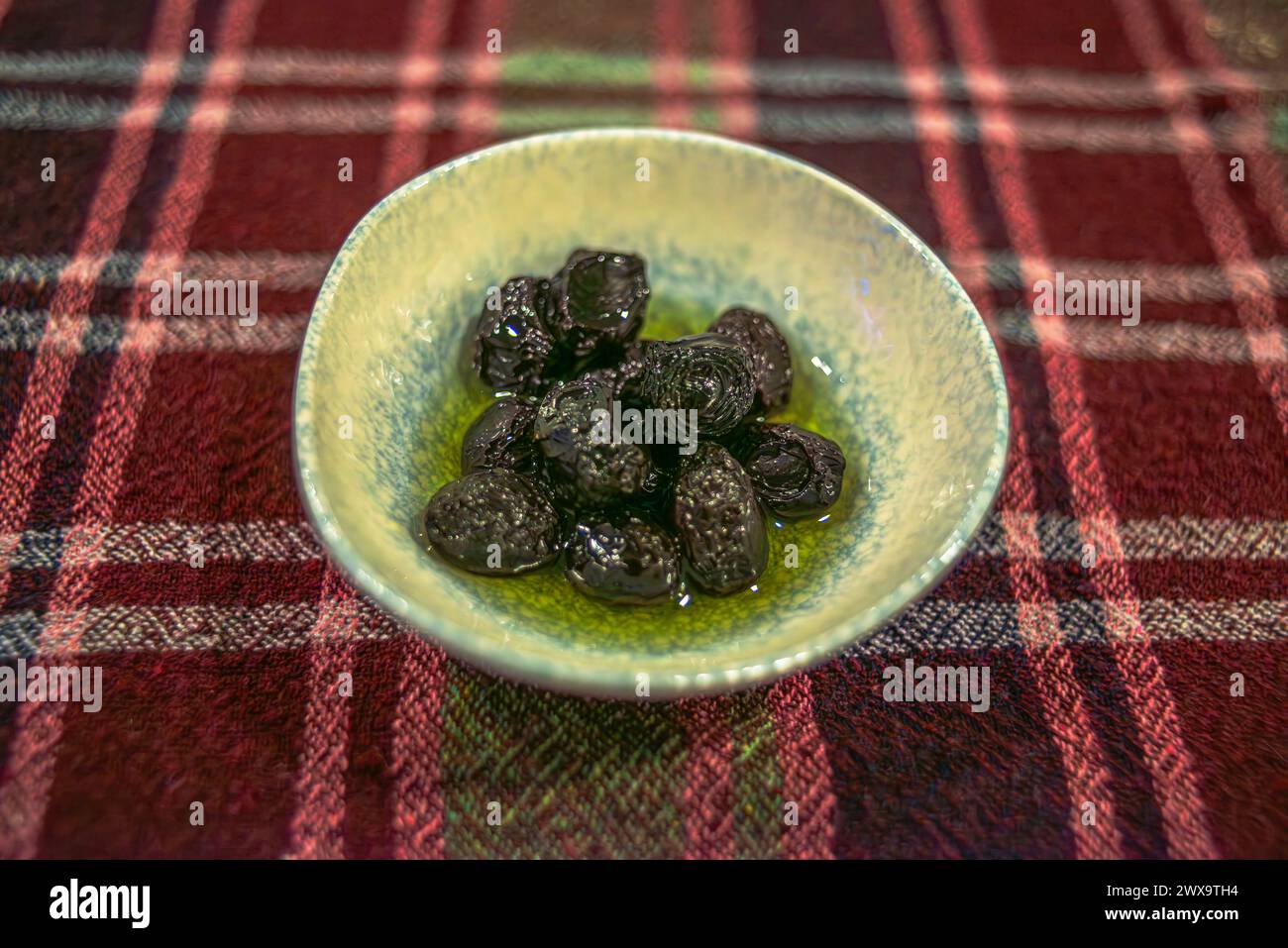 Offrez-vous un délice culinaire avec des olives dans un petit plat, offrant une gamme alléchante de saveurs et de textures dans un hors-d'œuvre savoureux. Banque D'Images
