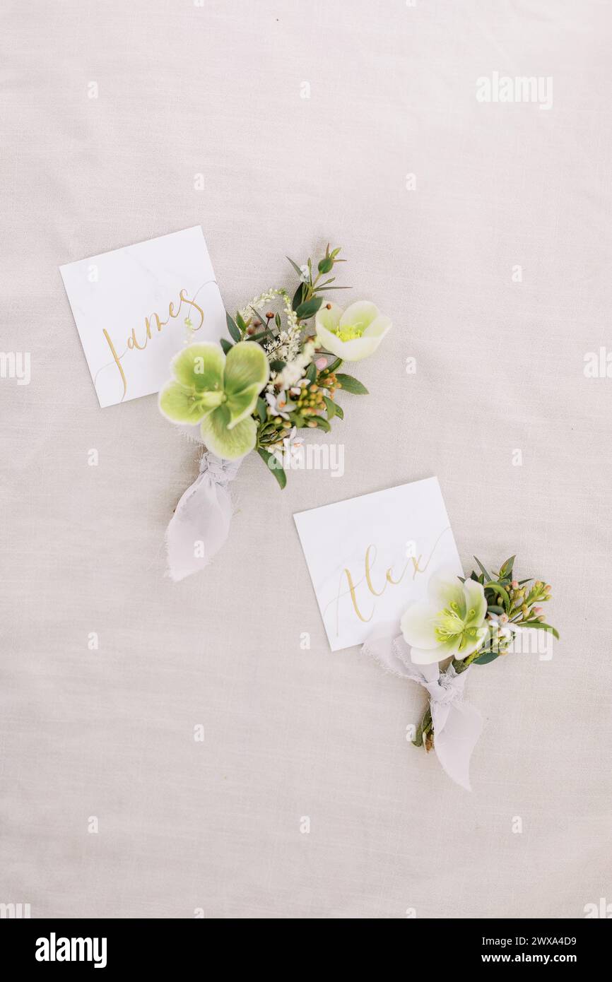 Boutonnières de mariage élégantes avec cartes à écriture dorée Banque D'Images