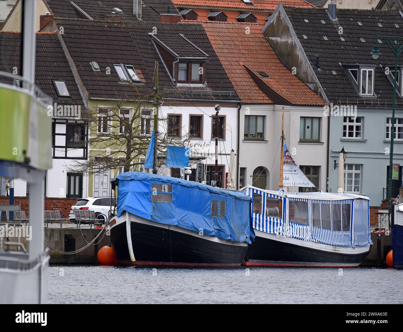 Wismar, Allemagne. 29 mars 2024. Les bateaux à vendre peuvent être vus dans le vieux port de Wismar. Sous un ciel gris, peu de voyageurs d'une journée sortent et circulent le vendredi Saint. Mecklenburg-Vorpommern attend de nombreux touristes pendant le long week-end de Pâques. Crédit : Frank Hormann/dpa-Zentralbild/dpa/Alamy Live News Banque D'Images