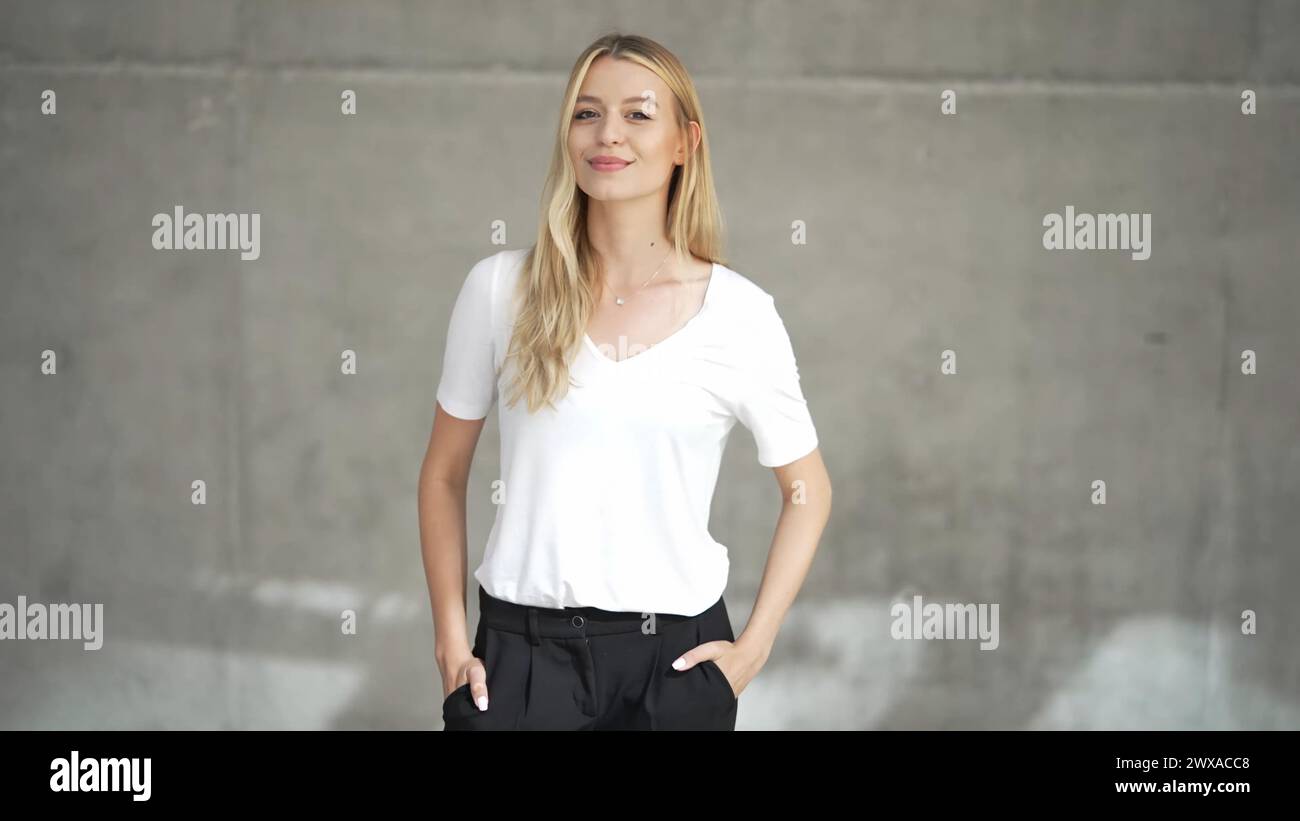 Femme confiante en T-shirt blanc décontracté posant Banque D'Images