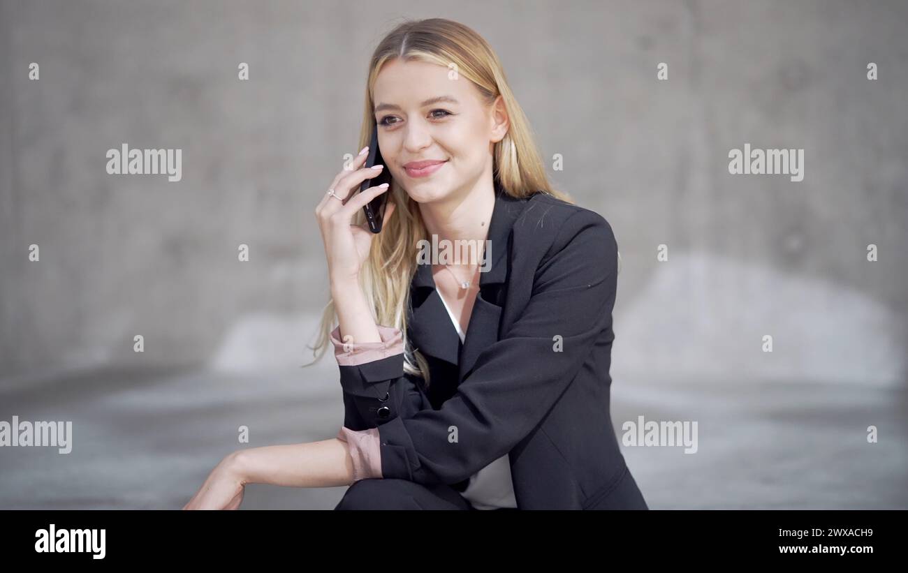 Femme professionnelle souriant tout en parlant au téléphone Banque D'Images