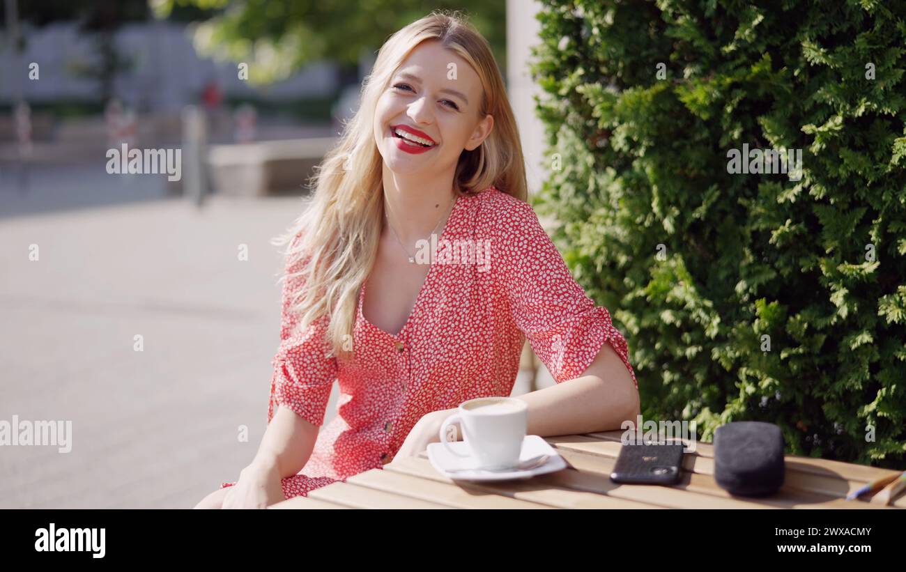 Femme souriante appréciant le café à l'extérieur un jour ensoleillé Banque D'Images