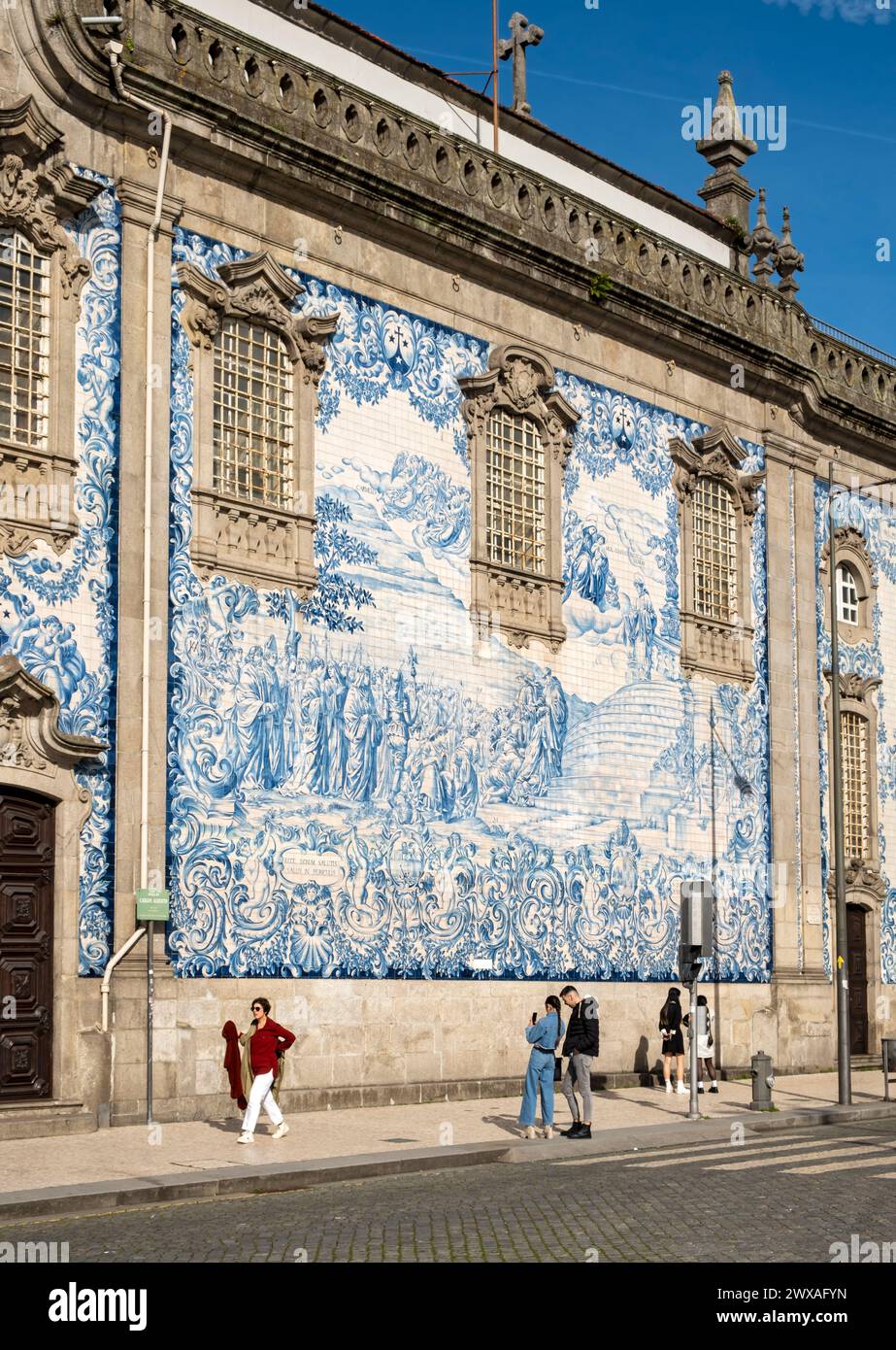 Les gens passent par la façade de l'église Igreja do Carmo, ornée de carreaux bleus et blancs complexes, Porto, Portugal Banque D'Images