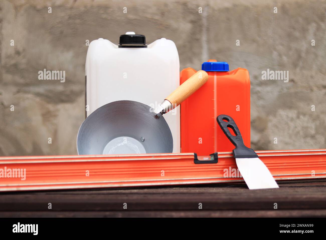 Poche de construction ou de plâtrage, spatule, niveau de construction et récipient pour apprêt. Rénovation de maison de campagne, construction. Composition et Banque D'Images