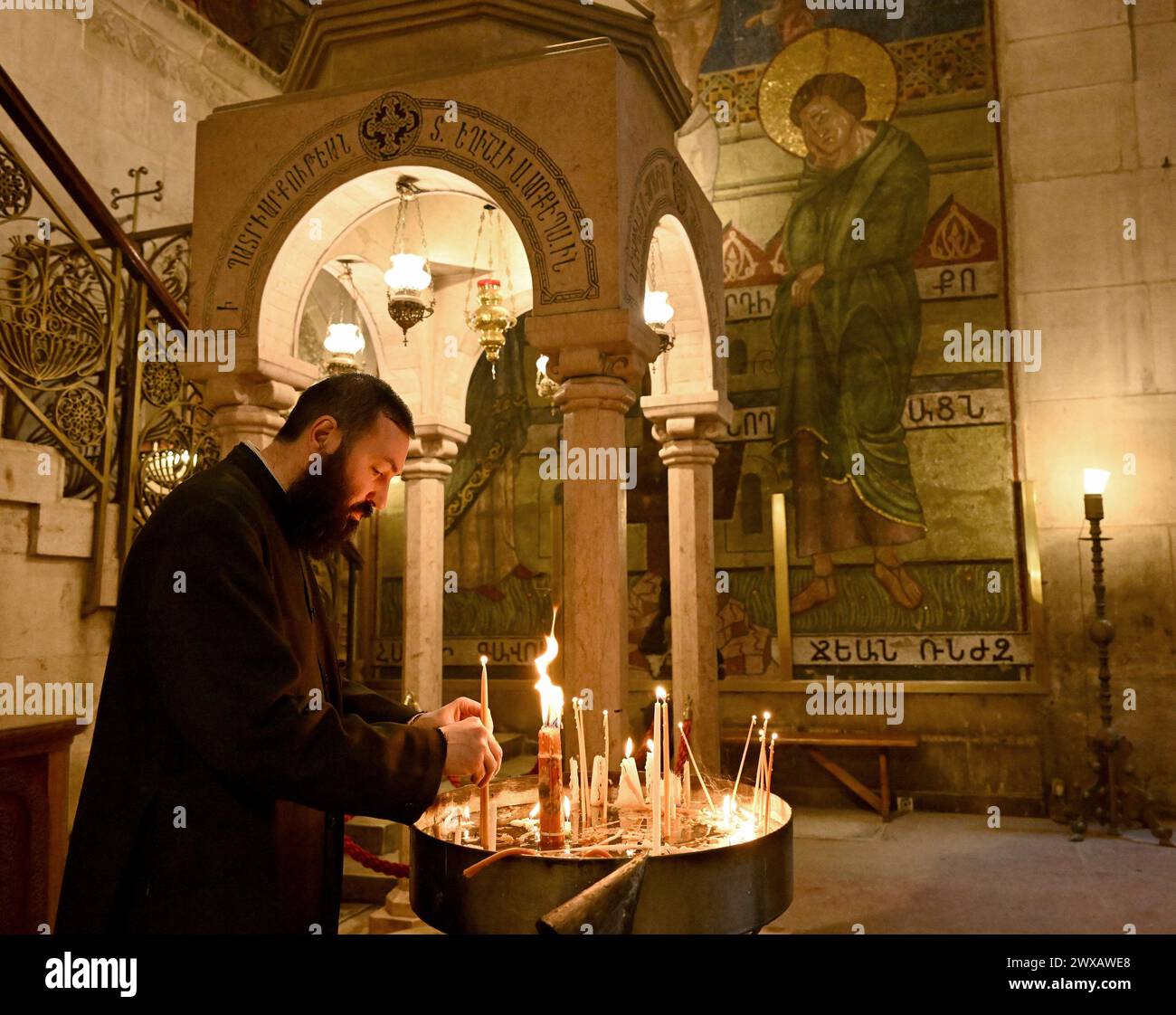 Vieille ville Jérusalem, Israël. 29 mars 2024. Un prêtre allume une bougie dans l'église du Saint-Sépulcre dans la vieille ville de Jérusalem le vendredi Saint, 29 mars 2024. Photo de Debbie Hill/ crédit : UPI/Alamy Live News Banque D'Images