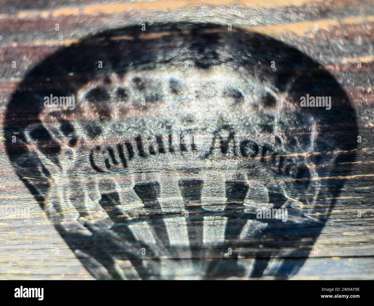 Échos éphémères. Logo du rhum Captain Morgan dans l'ombre reflet sur la table en bois altéré. 3. 29. 2024 Shtip Macédoine Banque D'Images