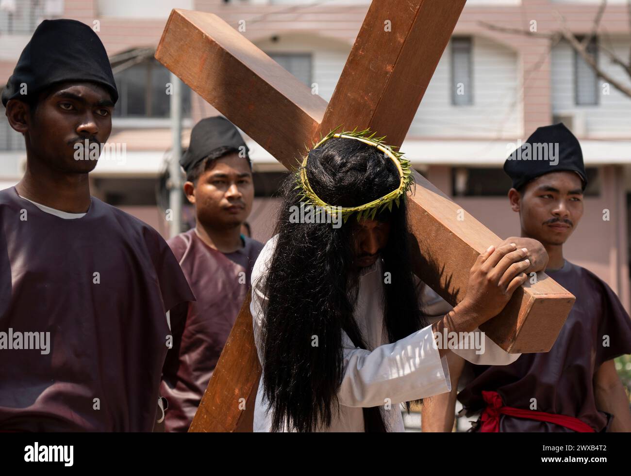 Les dévots chrétiens participent à une représentation pour la reconstitution de la crucifixion de Jésus-Christ lors d'une procession le vendredi Saint, le 29 mars 2024 à Guwahati, Assam, Inde. Le vendredi Saint est une fête chrétienne commémorant la crucifixion de Jésus-Christ et sa mort au Calvaire. Crédit : David Talukdar/Alamy Live News Banque D'Images