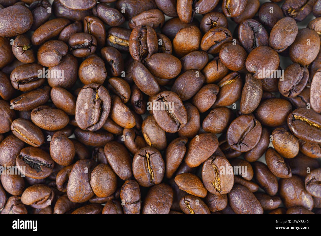 Gros plan sur les grains de café arabica torréfiés aromatiques, macro. Fond d'écran, texture, arrière-plan, vue de dessus. Banque D'Images