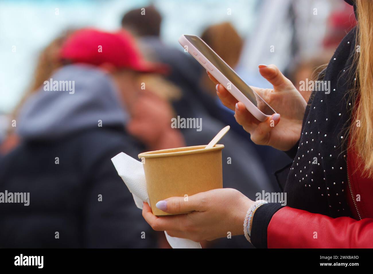 Mains des femmes tenant bol de nourriture et téléphone portable, section médiane du corps des femmes prenant selfie d'un repas au marché de l'alimentation de rue des agriculteurs à Prague Naplavka Banque D'Images