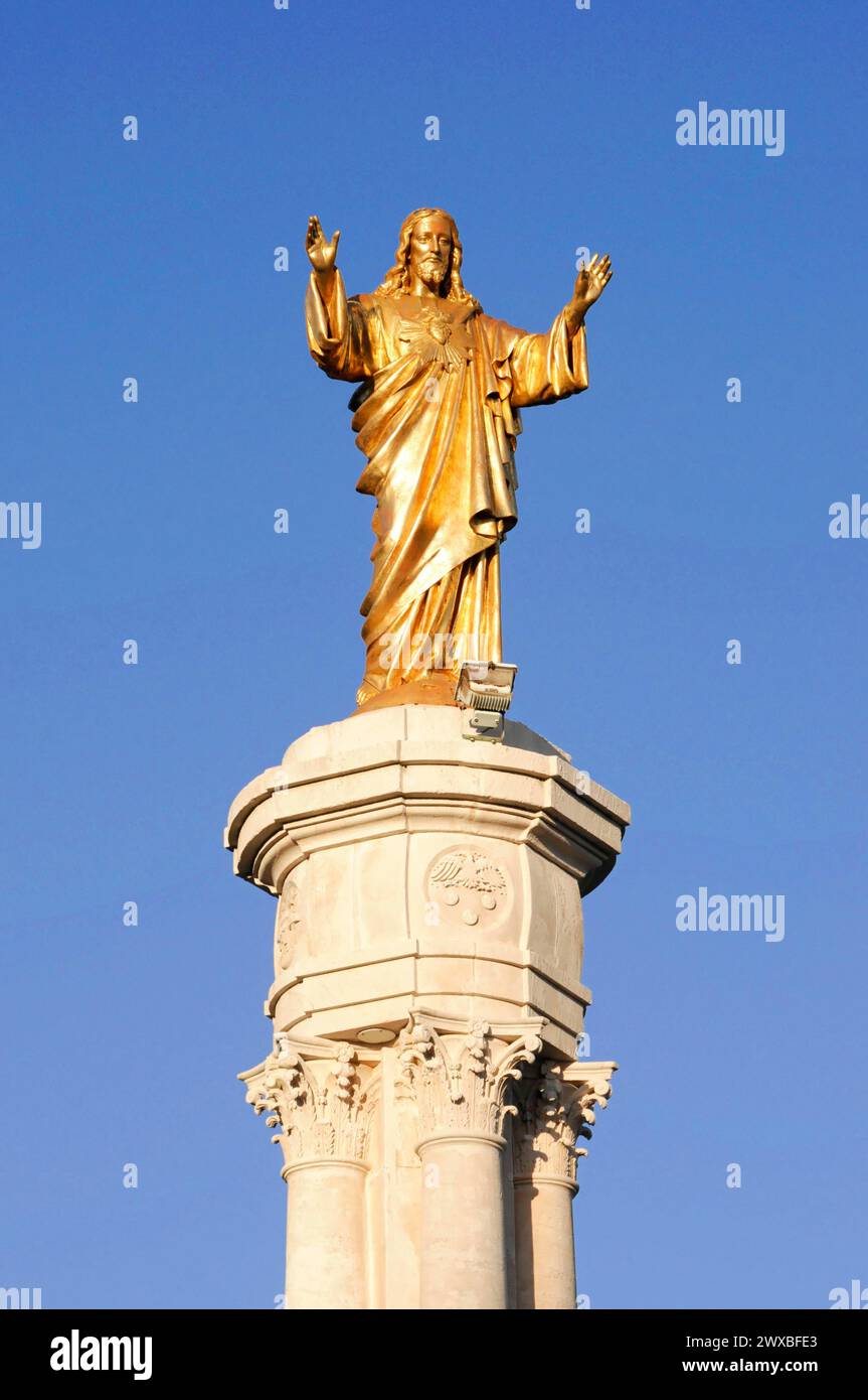 Statue du Christ, Fatima, lieu de pèlerinage, centre du Portugal, statue dorée de Jésus aux bras tendus devant un ciel bleu, nord du Portugal Banque D'Images