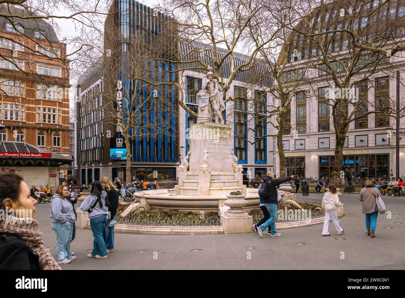 Une statue de William Shakespeare est la pièce maîtresse des Leicester Square Gardens à Londres depuis 1874. L'emblématique cinéma Odeon luxe à l'arrière. Banque D'Images
