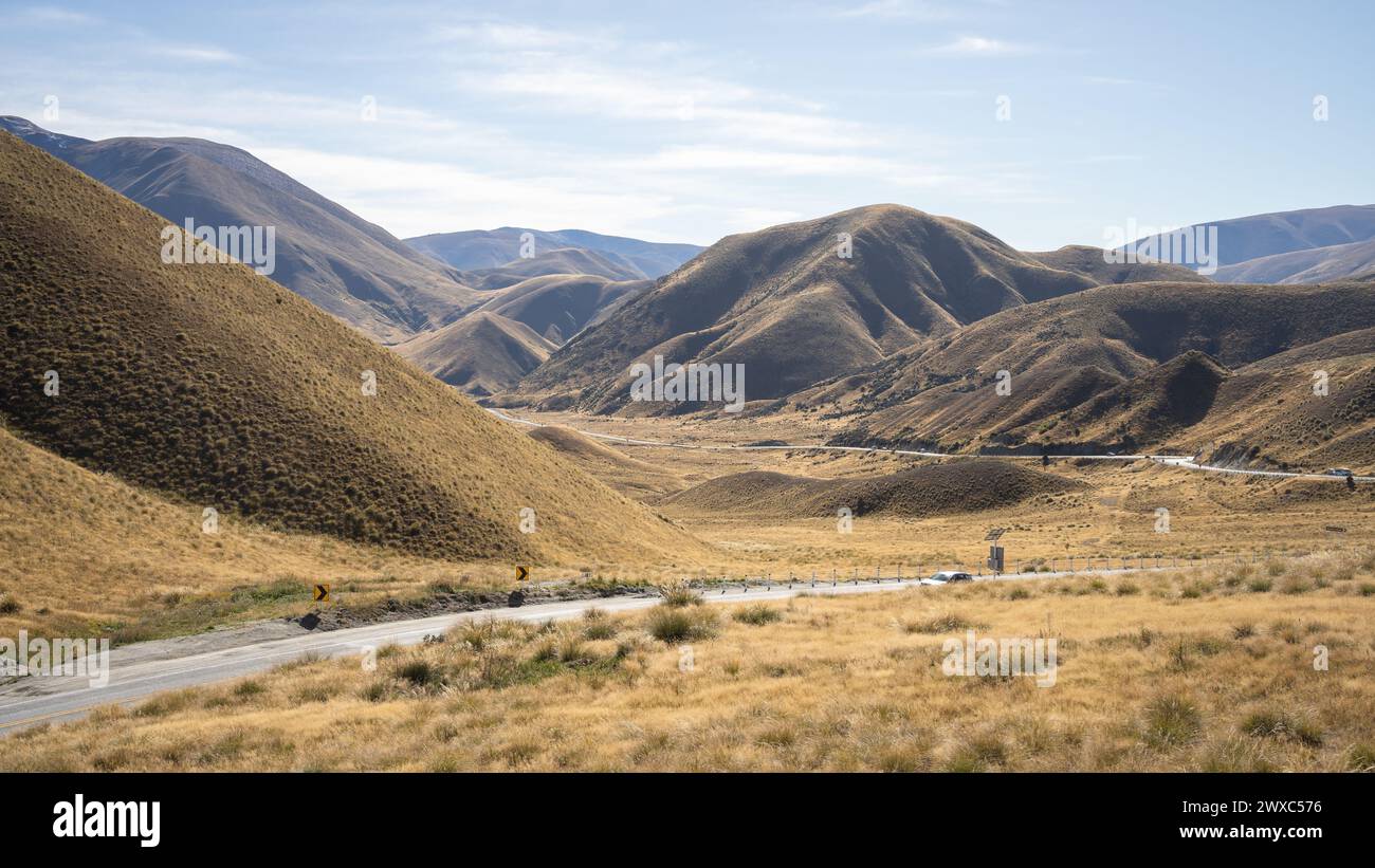 Col de haute montagne aux couleurs de l'automne avec autoroute sinueuse menant à travers elle, Nouvelle-Zélande. Banque D'Images