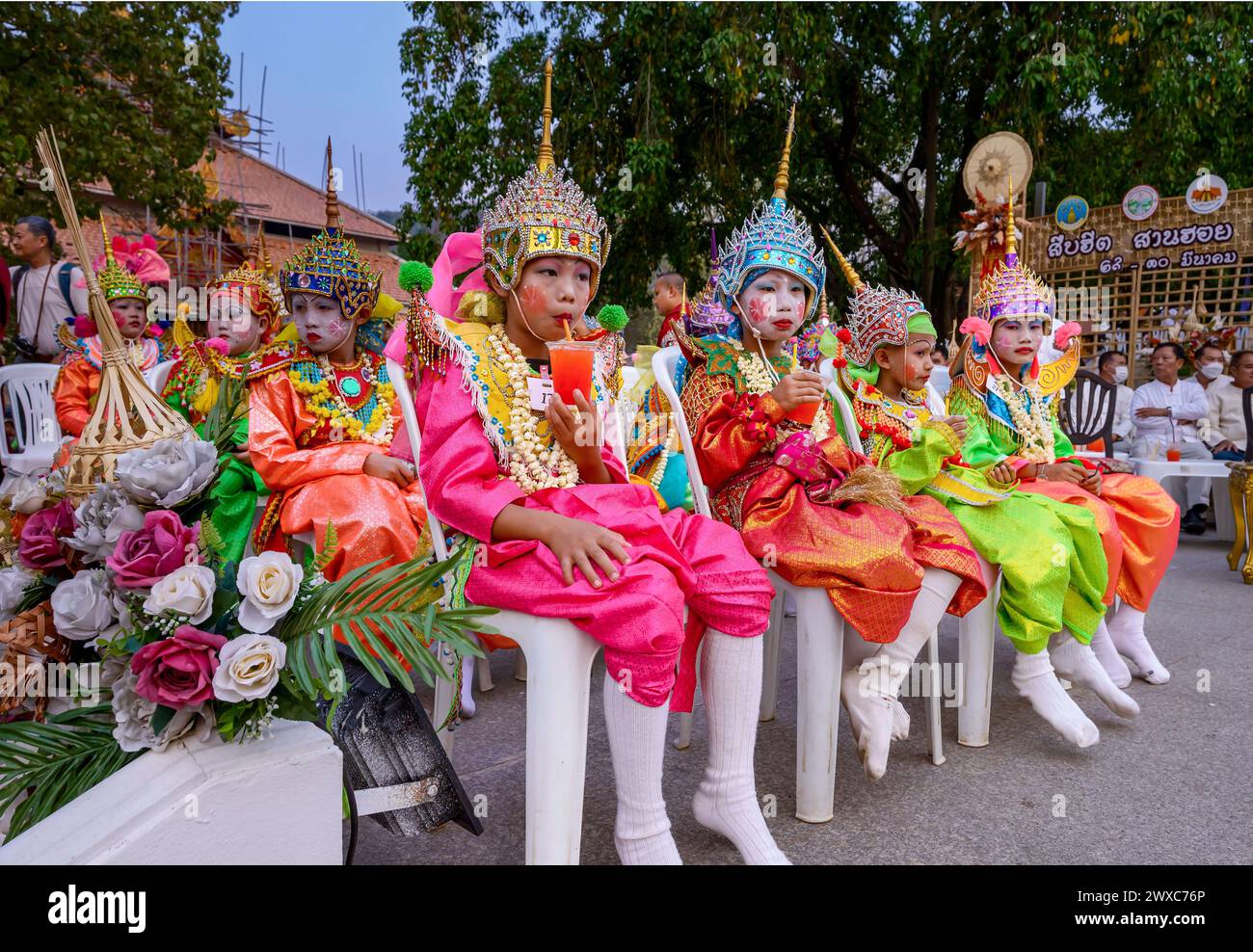 Thaïlande. 29 mars 2024. Les garçons thaïlandais vêtus de costumes colorés boivent de l'eau lors d'une célébration annuelle POI Luk Kaeo, un rite de passage traditionnel pour les garçons initiés en tant que novices bouddhistes au temple Wat Phra Phutthabat Tak Pha. POI Luk Kaeo est une célébration pour l'ordination des garçons qui ont l'intention d'entrer en tant que novices. Elle se tient généralement autour de février à mai, l'ordination en tant que luk kaeo ou novice est considérée comme l'une des cérémonies traditionnelles les plus importantes dans le nord de la Thaïlande. Crédit : SOPA images Limited/Alamy Live News Banque D'Images