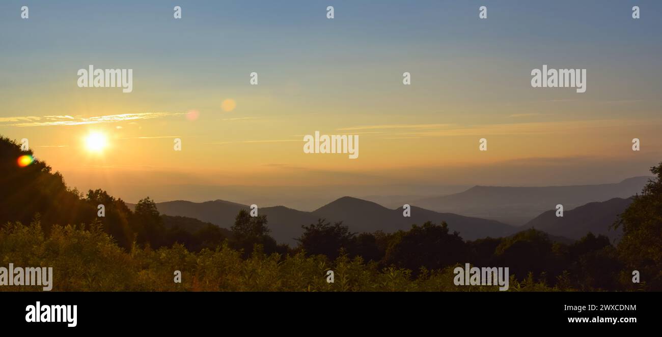 Un paysage panoramique image d'un coucher de soleil dans le parc national de Senandoah, pendant l'heure dorée avec les rayons du soleil créant un reflet d'objectif ; espace de copie Banque D'Images