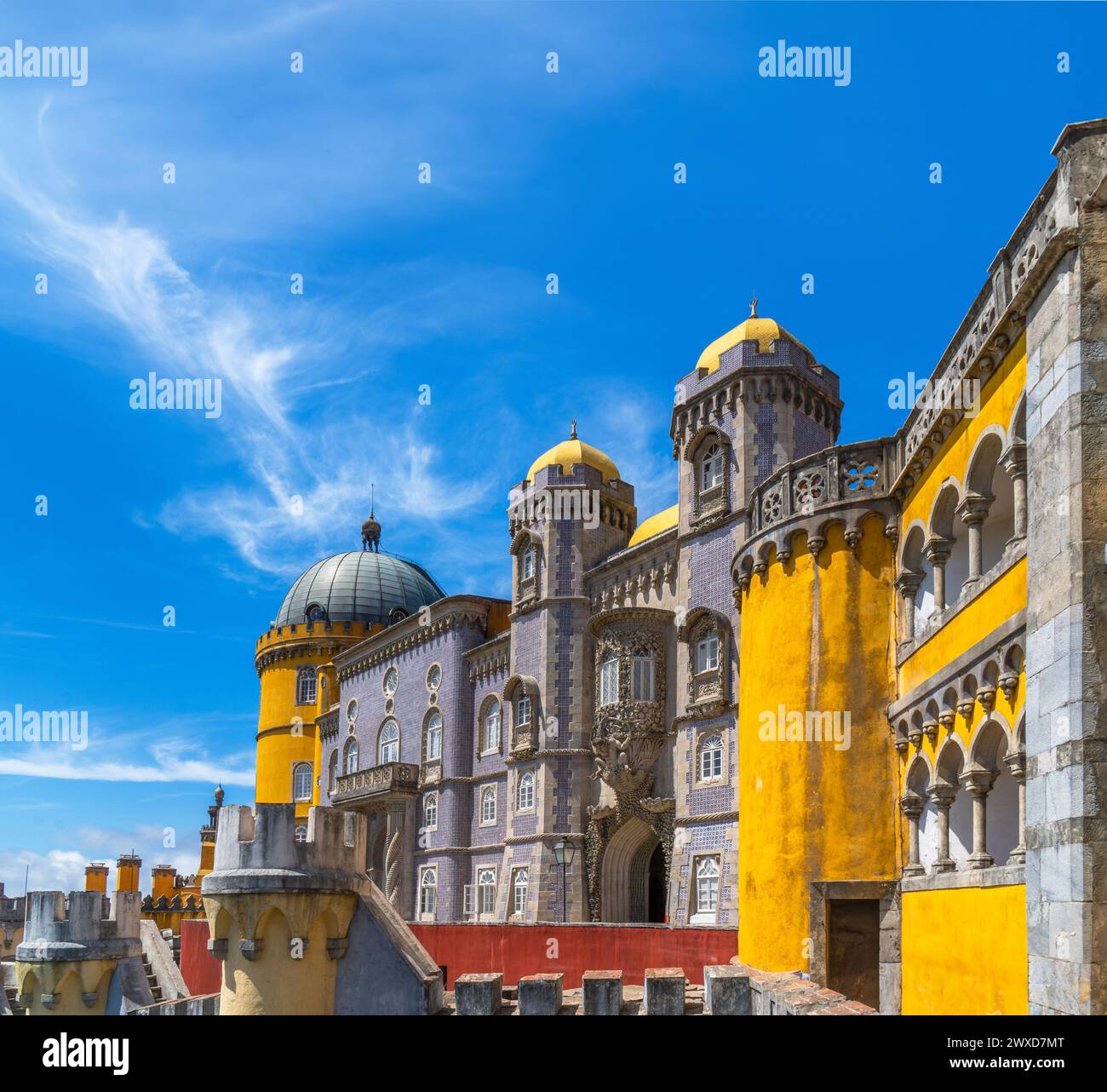 Vue extérieure du Palais de Pena avec des murs et des mosaïques jaunes et rouges sur le mur et les murs fortifiés, sous un ciel bleu ensoleillé. Sintra. Portugal. Banque D'Images