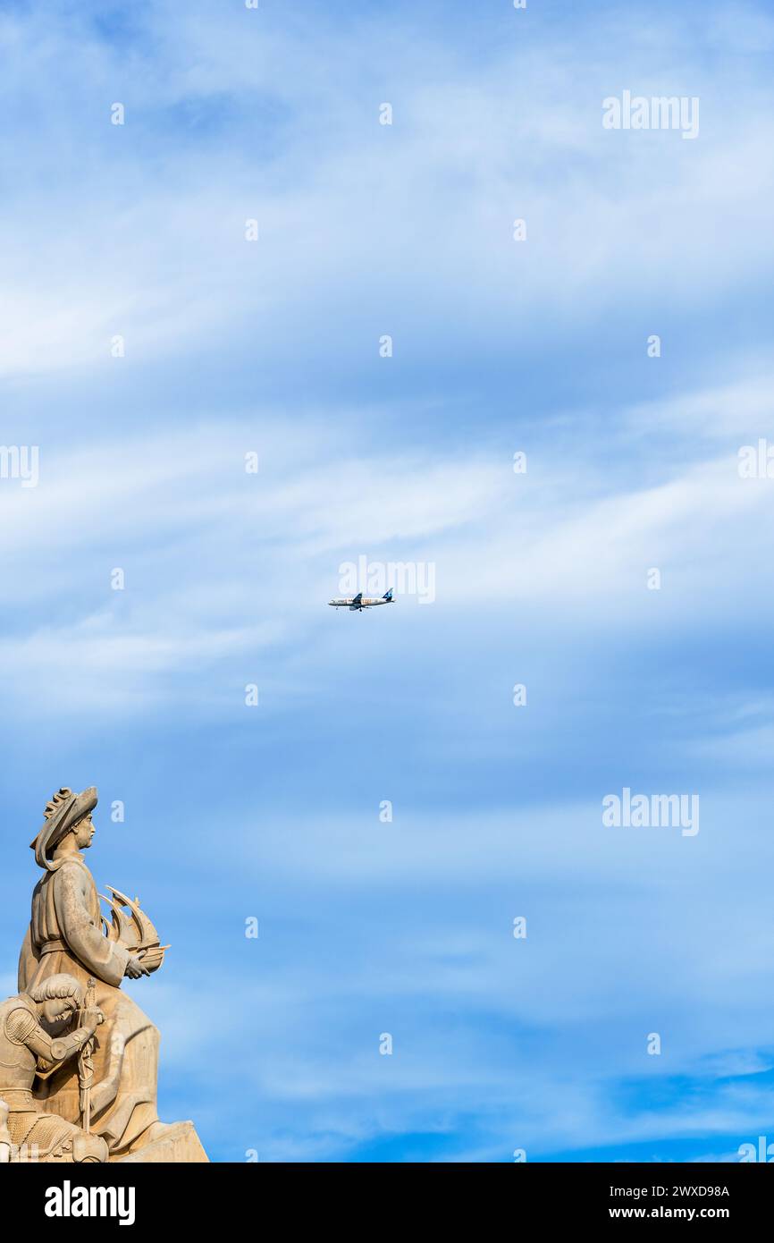 Limestone Monument to the Discoveries, avec Henry le navigateur tenant un navire regardant vers les Amériques avec un avion de passagers passant au-dessus Banque D'Images