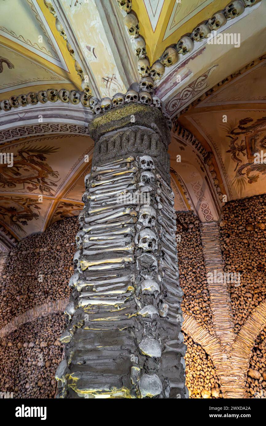 Colonne couverte et décorée d'os humains et de crânes et le plafond voûté avec des peintures allégoriques religieuses de la Chapelle des os. Evora, Banque D'Images