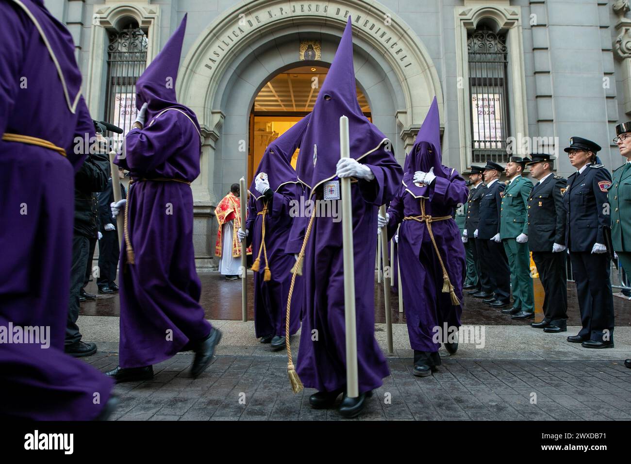 Madrid, Espagne. 29 mars 2024. Un groupe de Nazaréens vêtus de violet quittent en procession la basilique de Jesús de Medinaceli le vendredi Saint. Ce vendredi Saint, la fraternité de l'Archconfraternité primaire de l'esclavage réel et illustre du Nuestro Padre Jesús Nazareno de Medinaceli, populairement connu sous le nom de «Seigneur de Madrid», s'est déroulée comme chaque vendredi Saint à travers les rues du centre de Madrid. Crédit : SOPA images Limited/Alamy Live News Banque D'Images