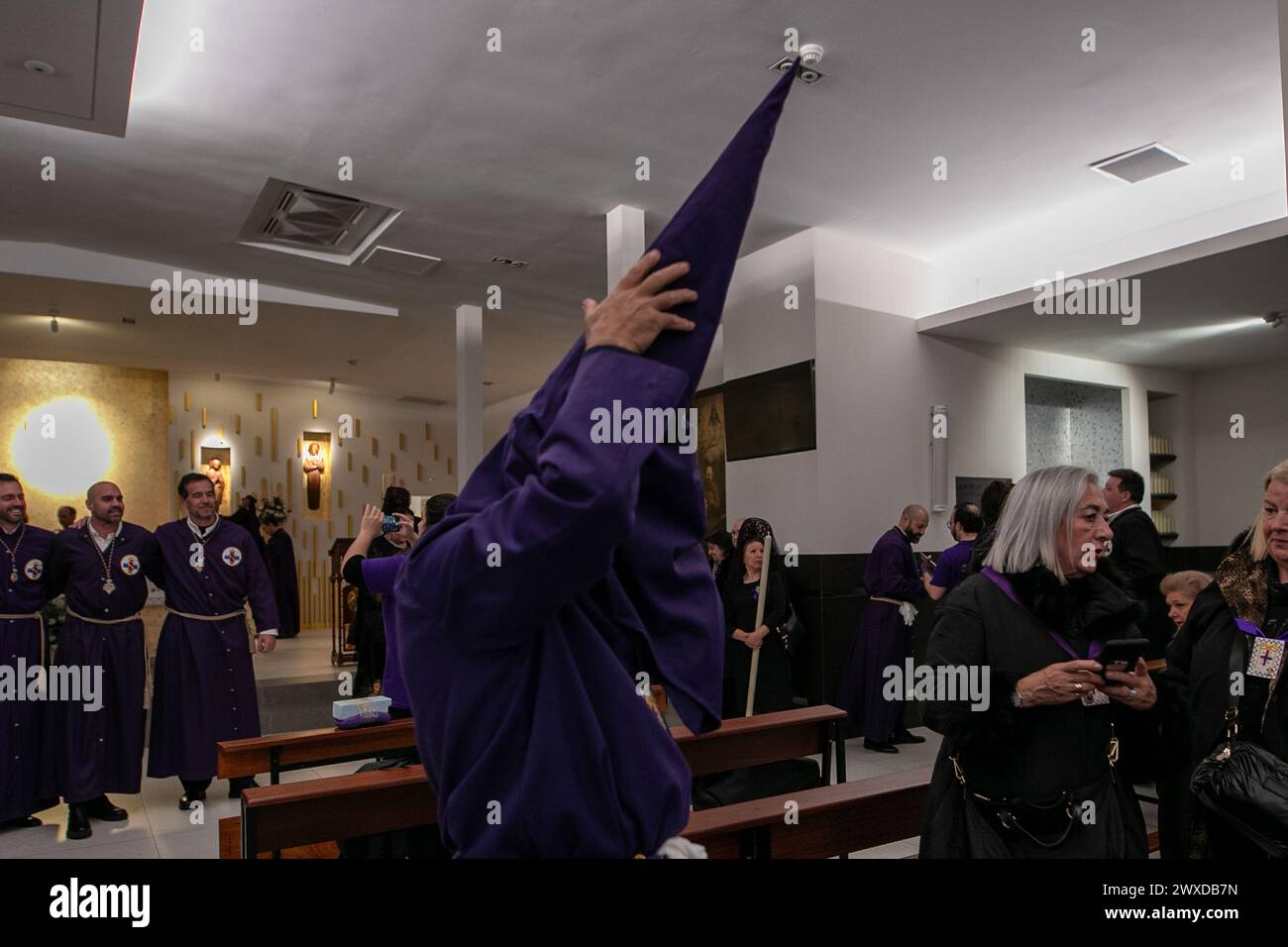 Madrid, Espagne. 29 mars 2024. Un pénitent vêtu de violet ajuste sa cagoule avant de partir en procession de la basilique de Jesús de Medinaceli le vendredi Saint. Ce vendredi Saint, la fraternité de l'Archconfraternité primaire de l'esclavage réel et illustre du Nuestro Padre Jesús Nazareno de Medinaceli, populairement connu sous le nom de «Seigneur de Madrid», s'est déroulée comme chaque vendredi Saint à travers les rues du centre de Madrid. Crédit : SOPA images Limited/Alamy Live News Banque D'Images