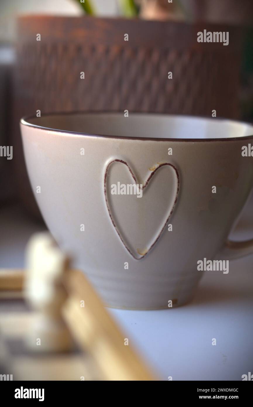 Jeu d'échecs - échiquier avec les pièces d'échecs et une tasse à café décorée avec un symbole de coeur Banque D'Images