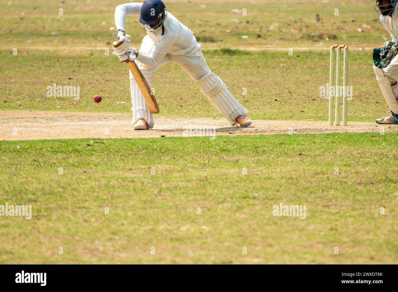 Le batteur de cricket joue un coup défensif en avant Banque D'Images