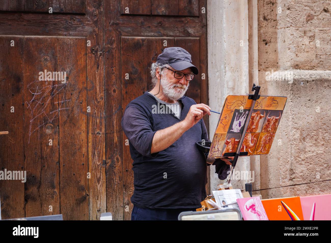 Palma de Majorque, Espagne - 29 avril 2023 : artiste de rue travaillant sur la toile de peinture dans le centre touristique d'une ville animée dans les îles Baléares Banque D'Images