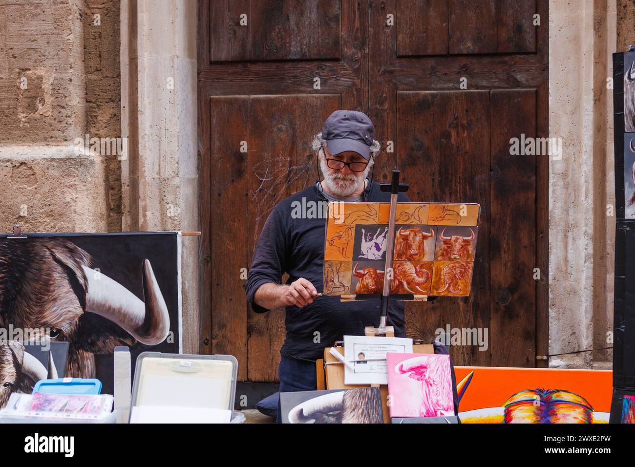 Palma de Majorque, Espagne - 29 avril 2023 : artiste de rue senior peint sur toile dans le centre-ville de Palma de Majorque et vend ses peintures Banque D'Images
