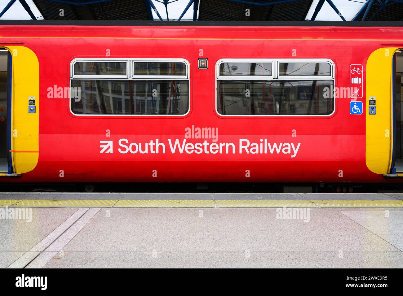 Londres, Royaume-Uni - 25 mars 2024 ; wagon de train South Western Railway avec nom et logo au quai en rouge sans personne Banque D'Images