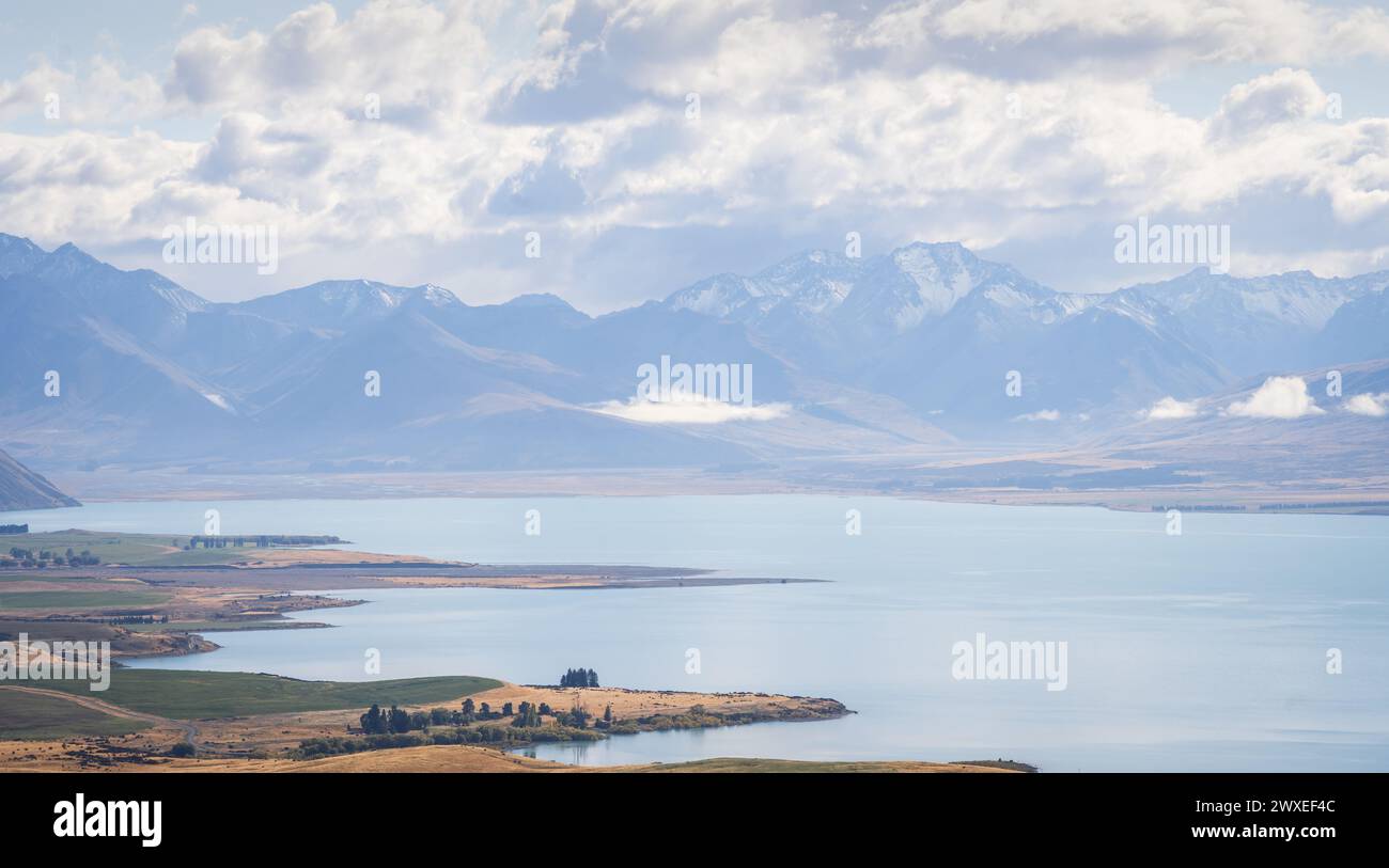Paysage néo-zélandais avec lac alpin turquoise et chaînes de montagnes enneigées en toile de fond. Banque D'Images