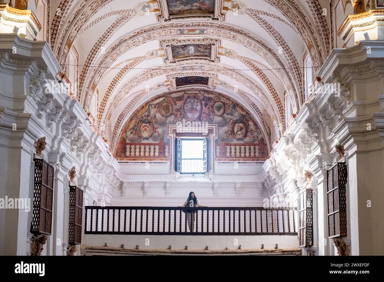 Une femme d'âge mûr regarde depuis le dernier étage de l'église catholique baroque de San Agustin à Almagro lors de sa visite de l'Espagne. La richne Banque D'Images