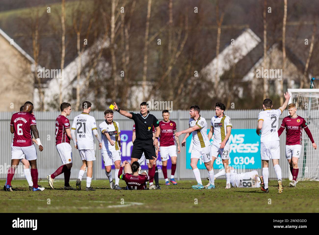 Dumbarton, Écosse. 30 mars 2024. Gregor Buchanan (4 - Stenhousemuir) est réservé après avoir fait tomber Finlay Gray (18 - Dumbarton) qui se brisait dangereusement sur la contre-attaque crédit : Raymond Davies / Alamy Live News Banque D'Images