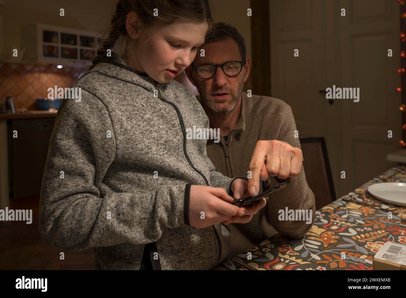 Père et fille, 10 ans, à la recherche de quelque chose avec leur téléphone portable, Mecklenburg-Vorpommern, Allemagne Banque D'Images