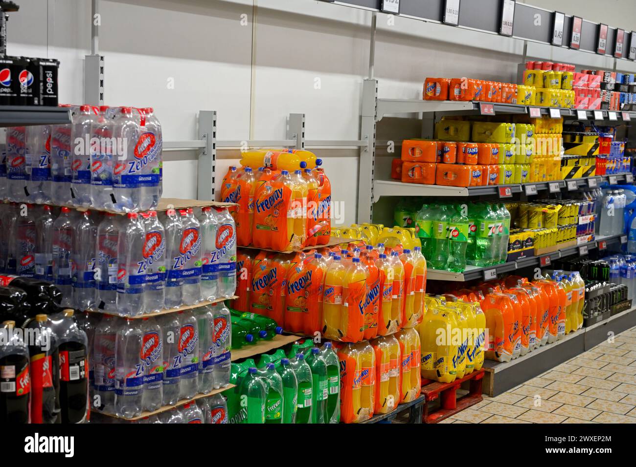 Piles et étagères de boissons gazeuses dans des bouteilles en plastique exposées au supermarché Lidl, Espagne Banque D'Images