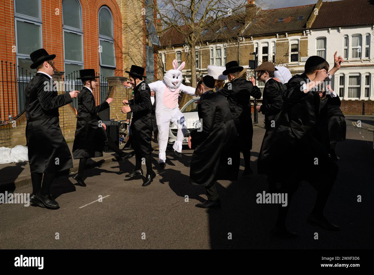 LONDRES, Royaume-Uni, 24 mars. La communauté juive de Stamford Hill, Londres célèbre la fête religieuse de Pourim. Les jeunes hommes dansent dans les rues et les enfants s'habillent de masques et de costumes. Banque D'Images