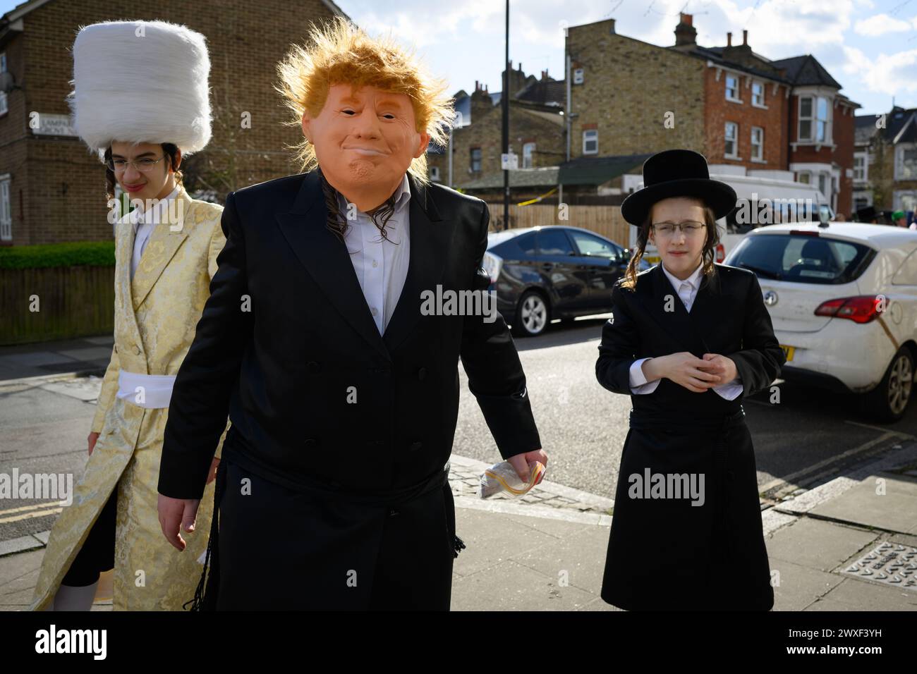 LONDRES, Royaume-Uni, 24 mars. La communauté juive de Stamford Hill, Londres célèbre la fête religieuse de Pourim. Les jeunes hommes dansent dans les rues et les enfants s'habillent de masques et de costumes. Banque D'Images