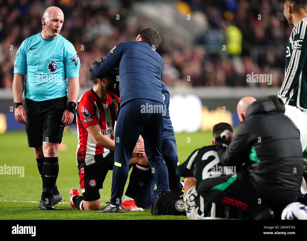 Neal Maupay de Brentford et Diogo Dalot de Manchester United reçoivent un traitement après une colinsion lors du match de premier League au Gtech Community Stadium de Londres. Date de la photo : samedi 30 mars 2024. Banque D'Images