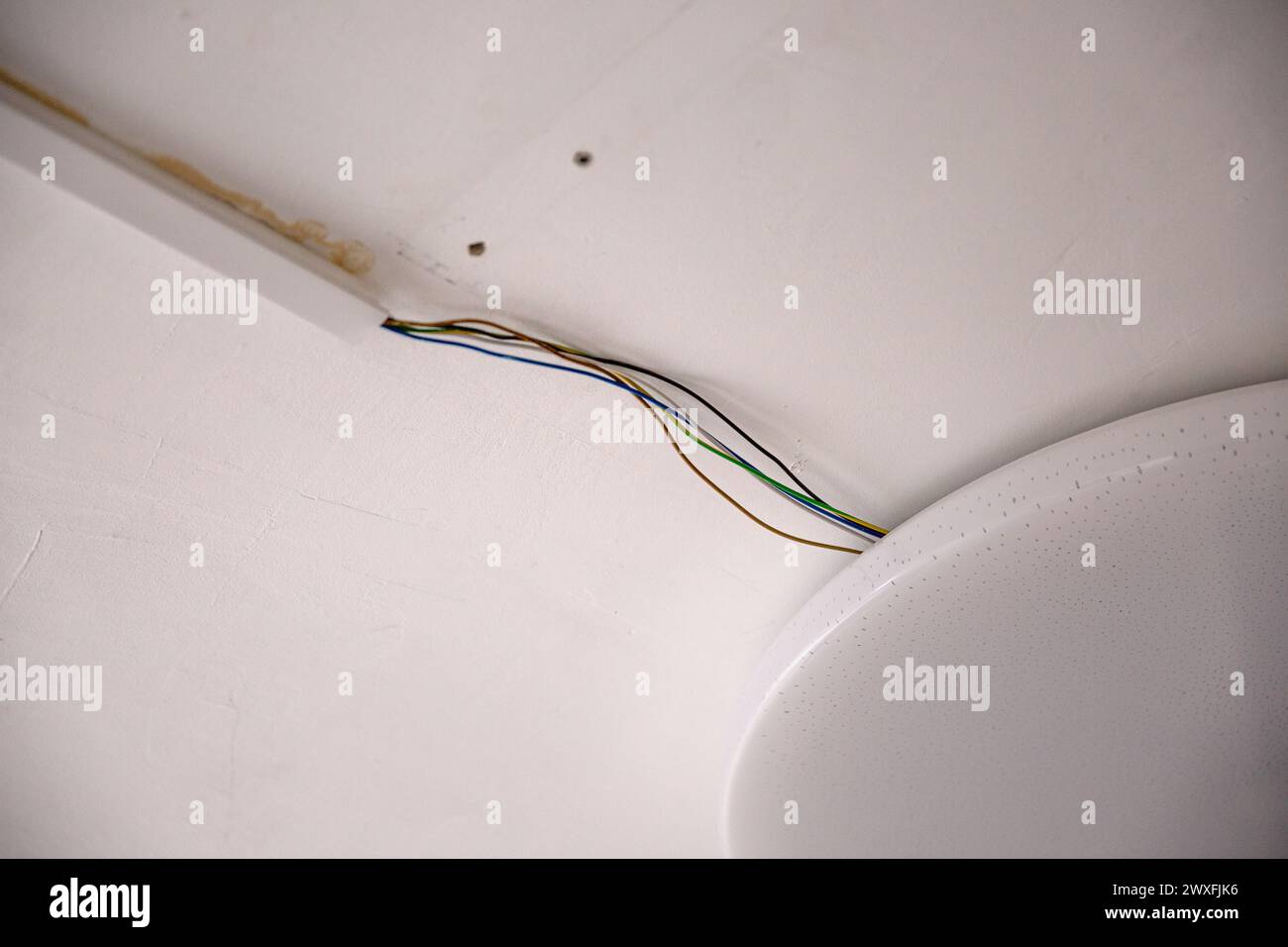 Câbles électriques dégradés sur un mur blanc Banque D'Images