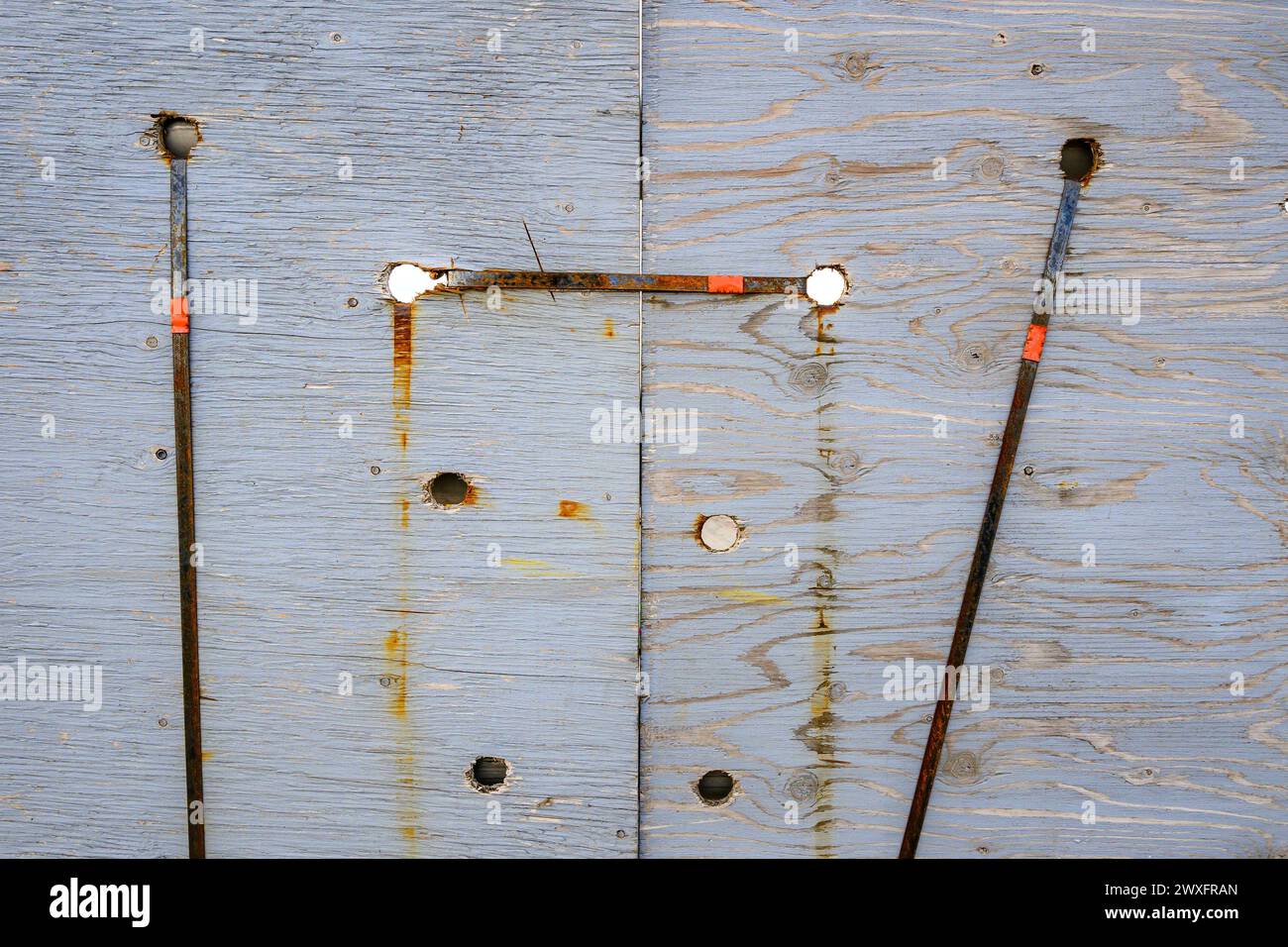 Les sangles en métal rouillé maintiennent les planches de barricade en bois. Les planches sont utilisées sur les passages supérieurs pour empêcher les chasse-neige de pousser la neige sur la route en contrebas. Banque D'Images